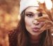 Woman in autumnal forest flowing a kiss
